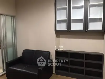 Modern living room with sleek black sofa and stylish storage cabinets.