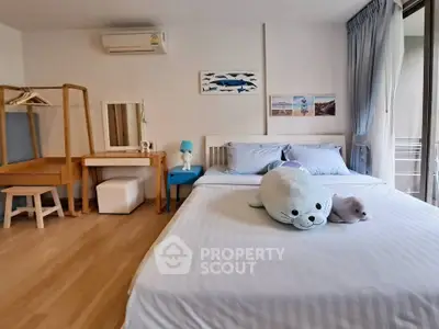 Cozy bedroom with plush toys and wooden furniture, featuring a large window for natural light.