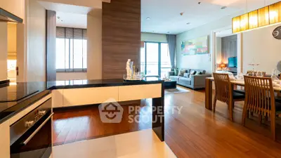 Spacious modern living room with open kitchen and elegant dining area in a luxury apartment.