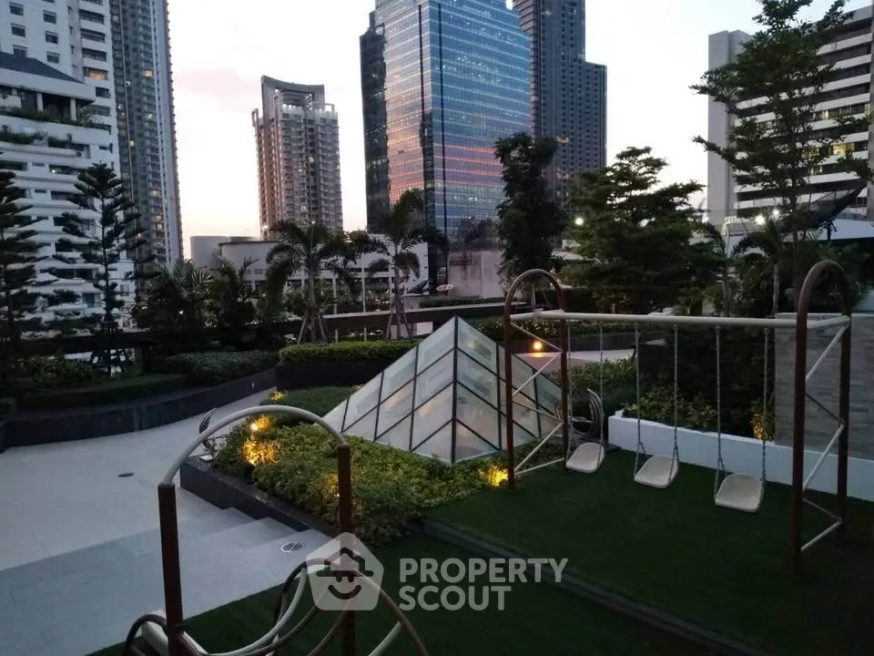 Modern urban playground with cityscape view and lush greenery.