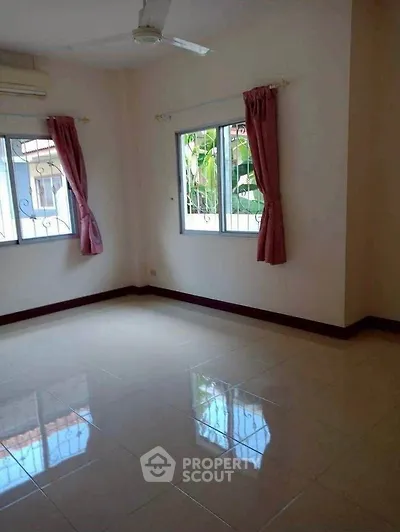 Spacious empty room with tiled floor and large windows, perfect for customization.