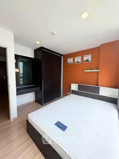 Modern bedroom with stylish decor and ample natural light, featuring a sleek wardrobe and cozy ambiance.