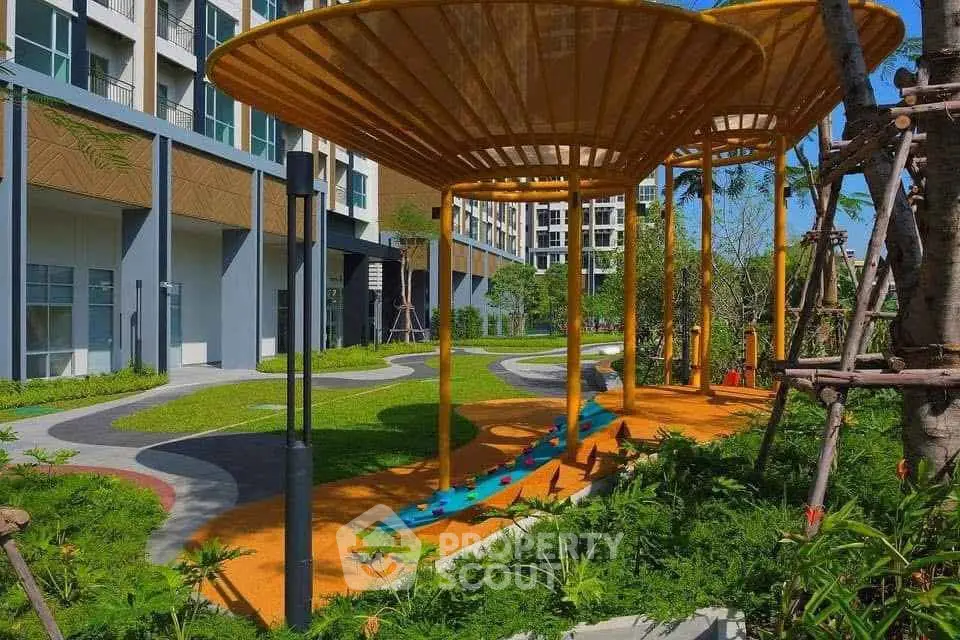 Modern apartment complex with landscaped garden and unique outdoor structures.