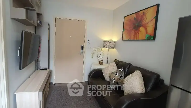 Cozy living room with modern decor and wall art, featuring a sleek TV setup.