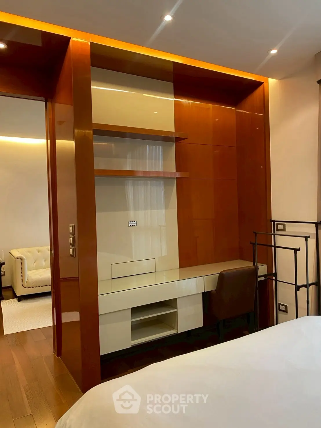 Modern bedroom with built-in desk and shelving, featuring warm wood tones and sleek design.