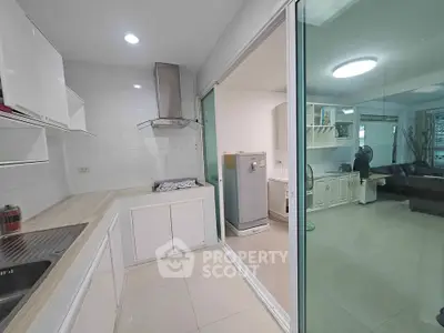 Modern kitchen with sleek design and open layout leading to spacious living area.