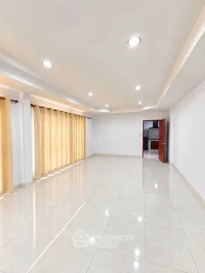 Spacious and bright living room with tiled flooring and recessed lighting
