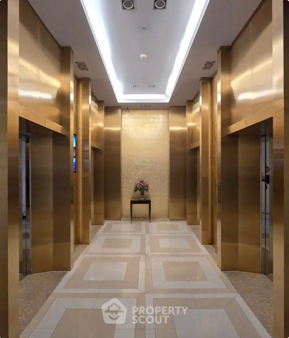 Luxurious building lobby with golden elevators and elegant decor