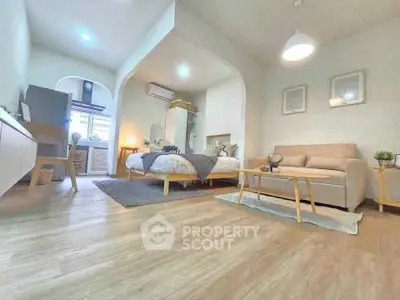 Spacious modern living room with cozy seating and stylish decor in open-plan apartment.