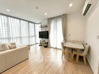 Spacious modern living room with large windows and elegant dining area