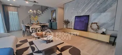 Luxurious modern living room with elegant decor and open dining area, featuring stylish furniture and artistic accents.