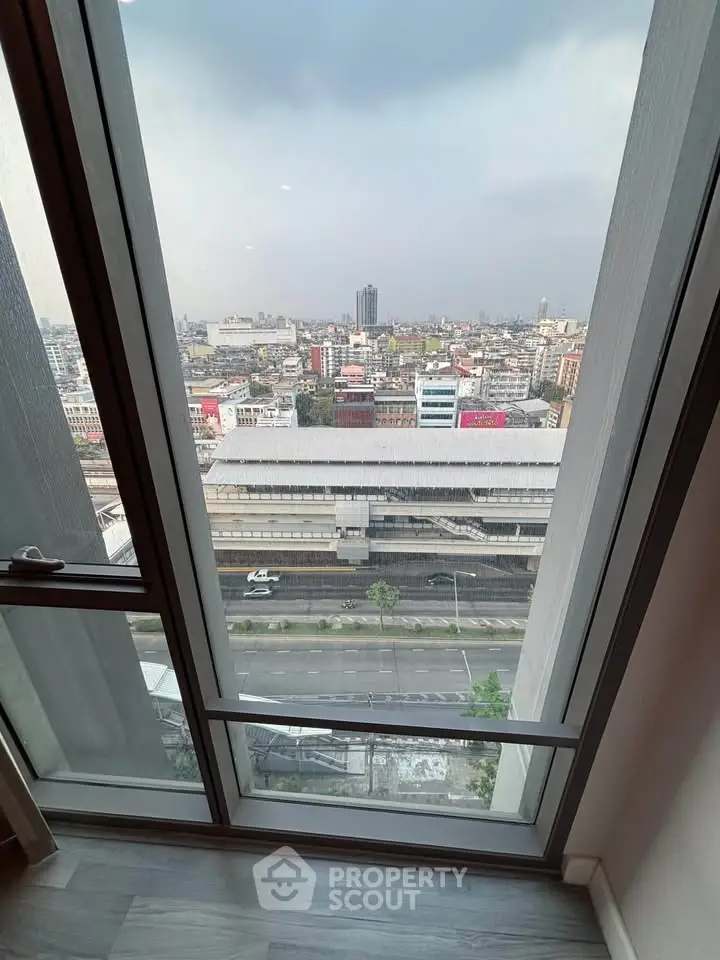 Stunning cityscape view from high-rise apartment window, showcasing urban skyline and bustling streets below.