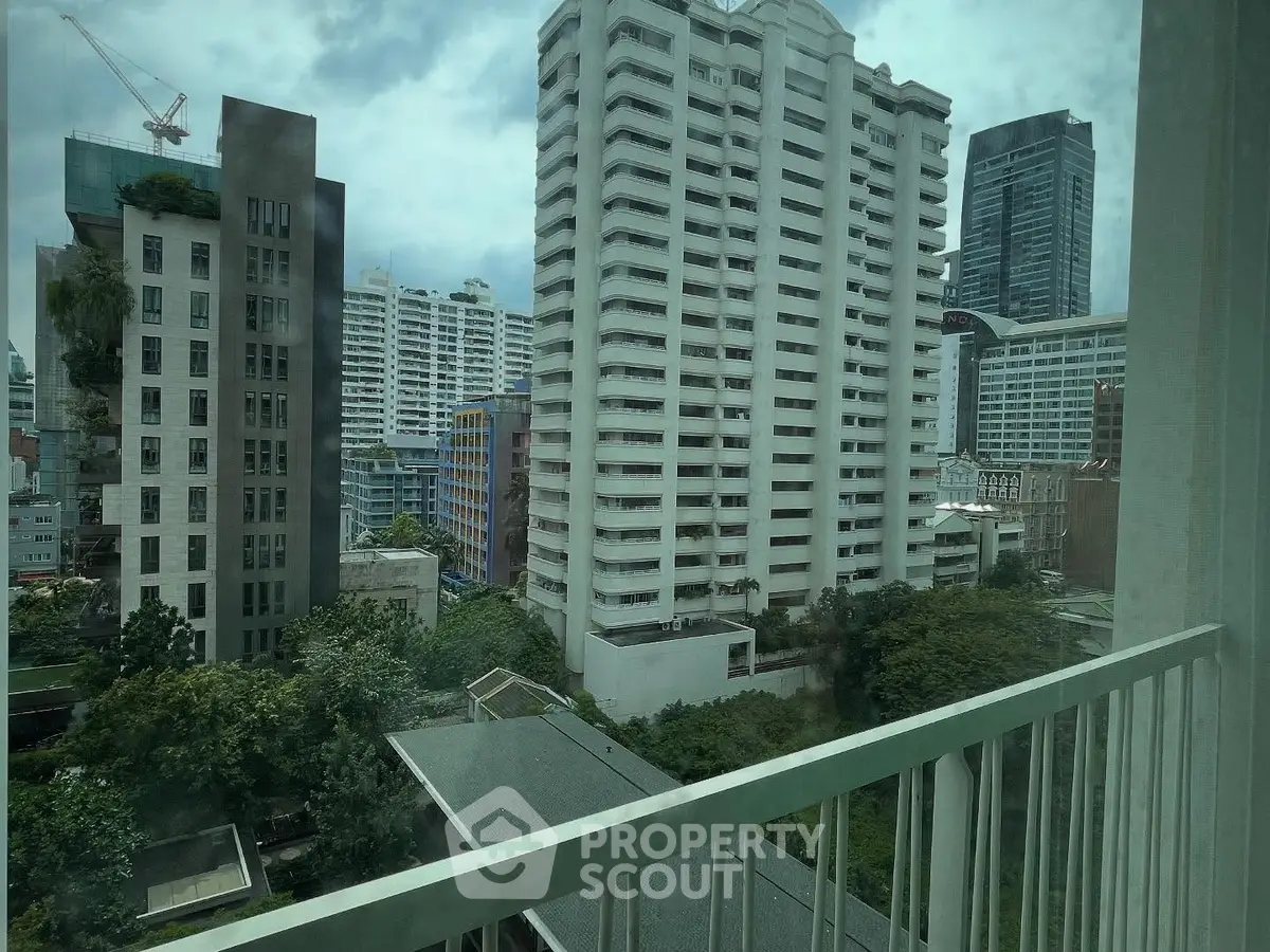 Stunning cityscape view from a high-rise balcony overlooking modern urban architecture.