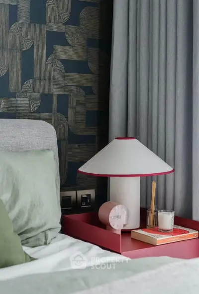Stylish bedroom with modern decor, featuring a unique lamp and textured wallpaper.