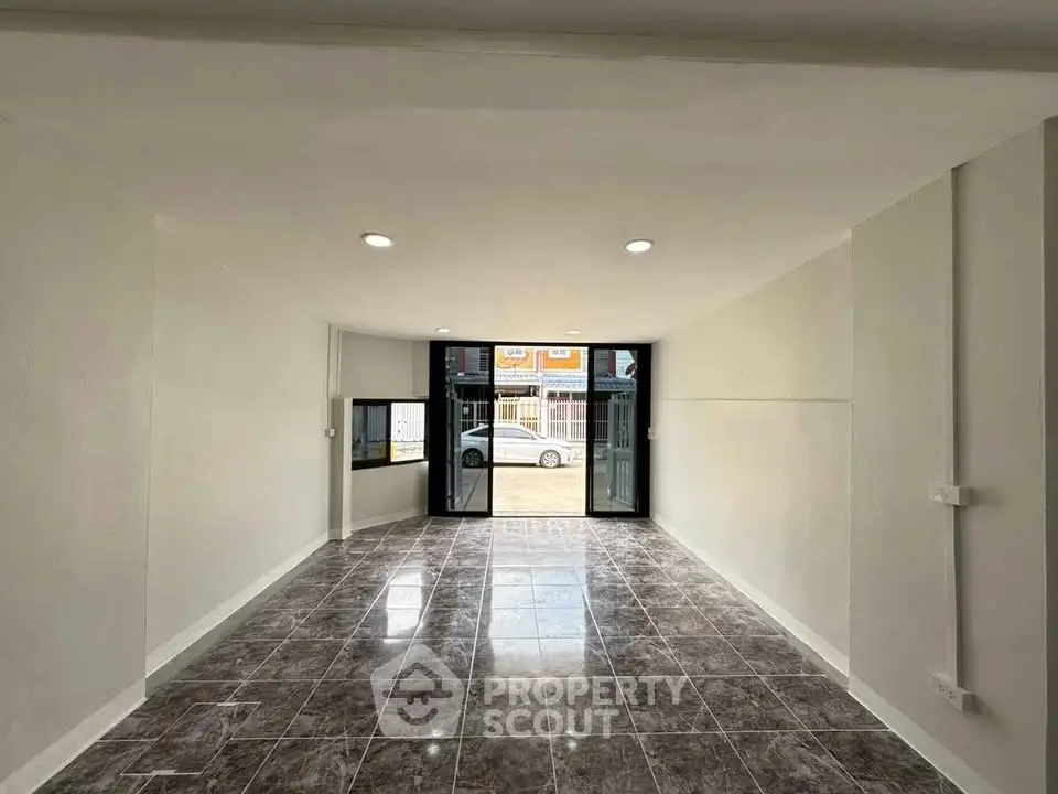 Spacious modern living room with large windows and glossy tiled floor