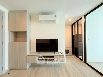 Modern living room with sleek wooden furniture and large TV, featuring a minimalist design and air conditioning.