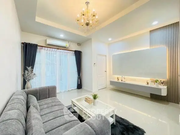 Elegant living room with chandelier, modern sofa, and large mirror