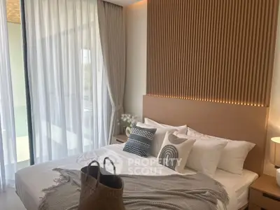 Elegant bedroom with modern decor and large windows offering natural light.