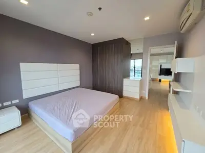 Spacious modern bedroom with wooden flooring and stylish decor