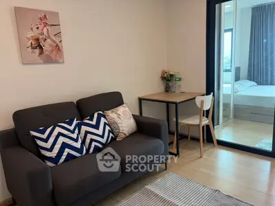 Cozy living room with modern decor and view into a bright bedroom