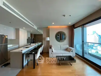 Modern open-layout living room with balcony and city view, featuring sleek furniture and hardwood floors.