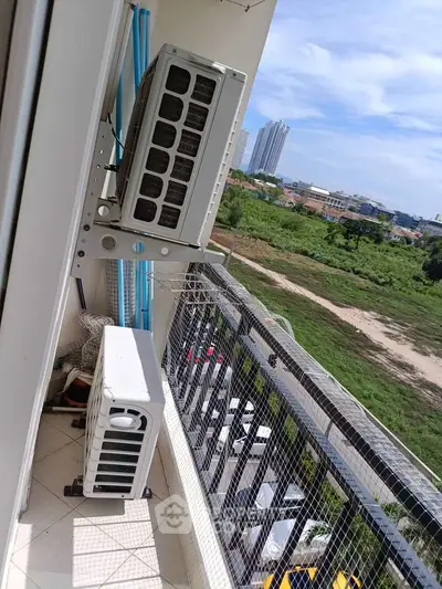 Spacious balcony with air conditioning units and scenic city view, perfect for relaxation and outdoor enjoyment.