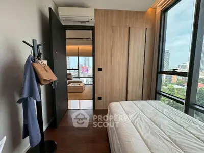 Modern bedroom with city view, featuring wooden accents and large windows for natural light.