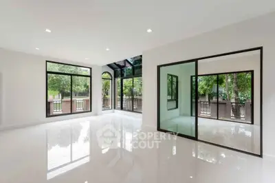 Spacious modern living room with large windows and glossy floors