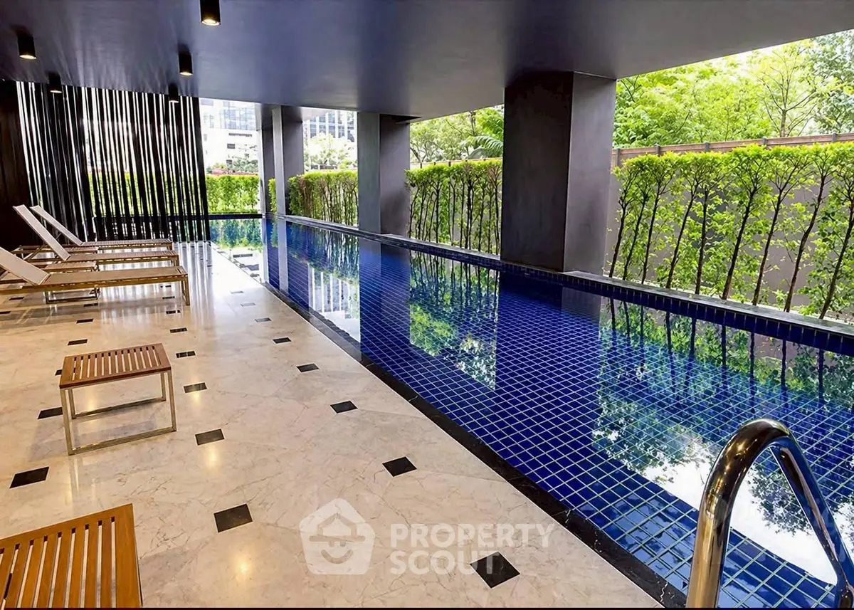 Luxurious indoor pool area with modern design and greenery view, perfect for relaxation and leisure.