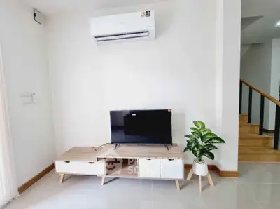 Modern living room with sleek TV stand and air conditioning unit, perfect for cozy relaxation.