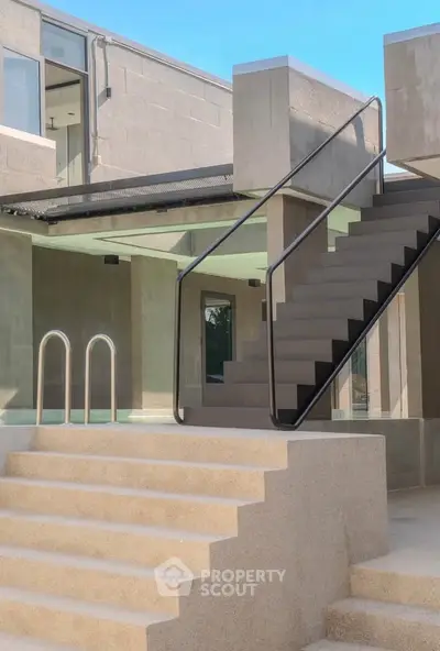 Modern architectural exterior with sleek staircase and minimalist design.