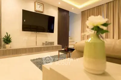 Modern living room with wall-mounted TV, elegant decor, and cozy ambiance.