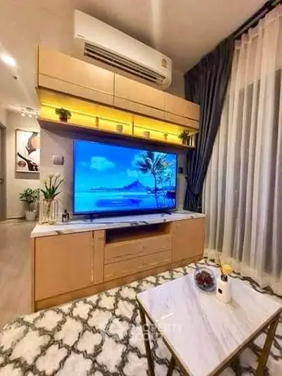 Modern living room with stylish decor and large TV, featuring elegant lighting and cozy ambiance.