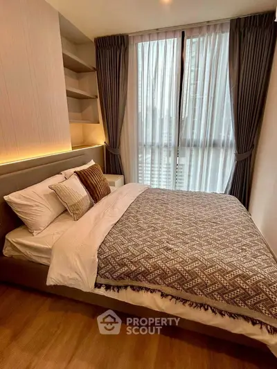 Cozy bedroom with stylish decor and large window for natural light