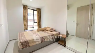 Modern bedroom with large window and stylish decor in a contemporary apartment.