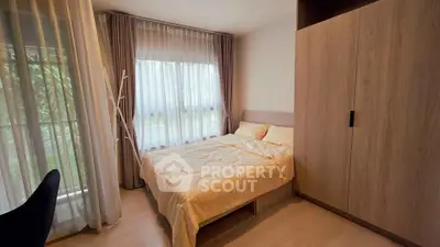 Cozy bedroom with large window and modern wooden wardrobe, perfect for relaxation.