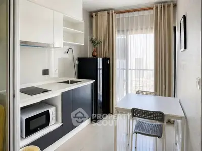 Modern kitchen with sleek design, featuring a compact dining area and large window for natural light.