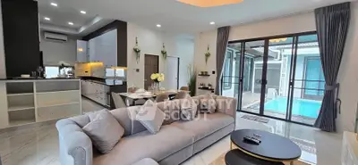 Luxurious open-plan living room with pool view and modern kitchen