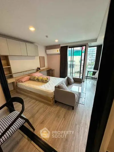 Modern bedroom with balcony view, featuring stylish furniture and ample natural light.