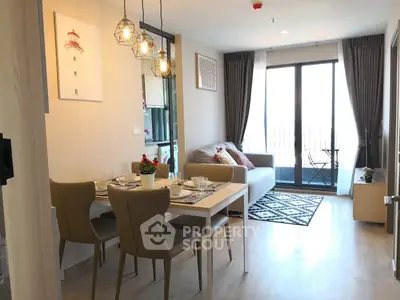 Modern living room with dining area, stylish lighting, and balcony access in a cozy apartment.