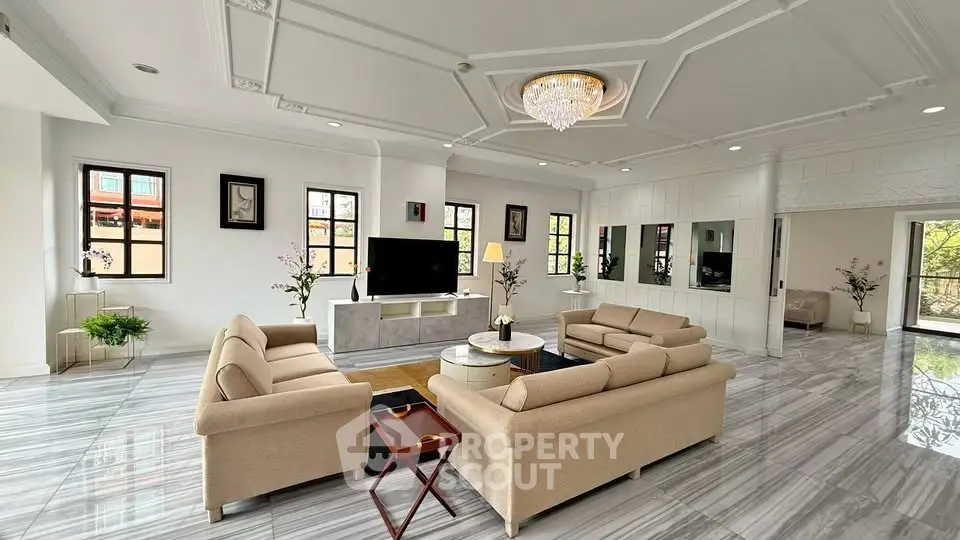 Luxurious living room with elegant chandelier and spacious seating area in modern home.