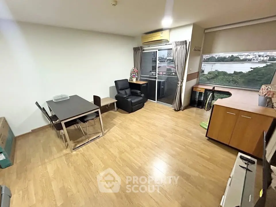 Spacious living room with wooden flooring and balcony view