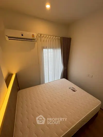 Cozy bedroom with natural light and modern air conditioning unit.