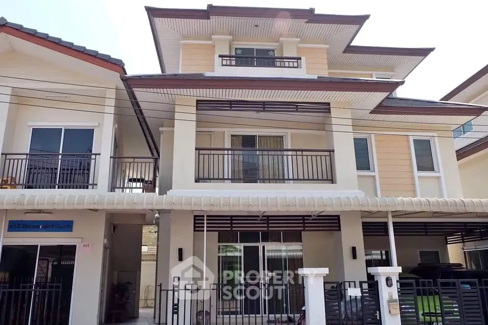 Modern multi-story house with spacious balcony and contemporary design in a suburban neighborhood.