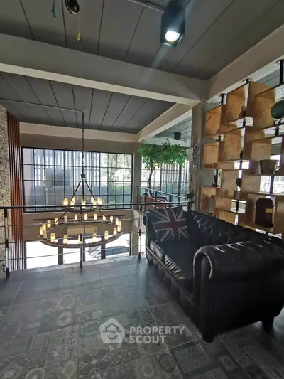 Stylish loft interior with modern chandelier and cozy seating area