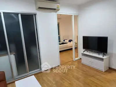 Modern apartment interior with wooden flooring, sliding doors, and air conditioning unit.
