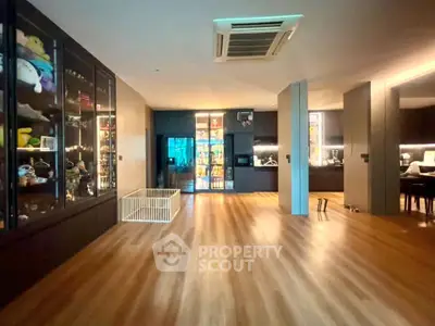 Spacious open-plan living area with wooden flooring and modern lighting, ideal for family gatherings.