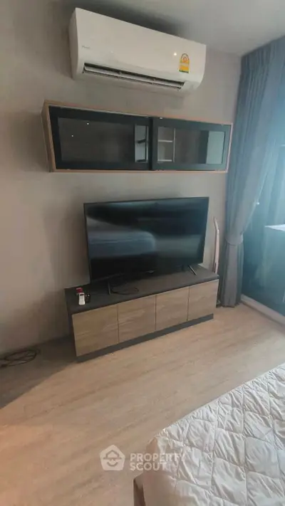 Modern bedroom with wall-mounted TV and air conditioning unit