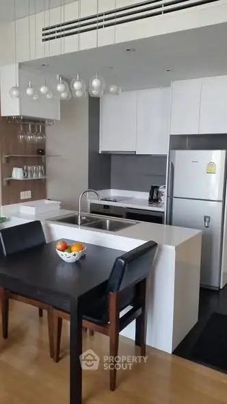 Modern kitchen with sleek white cabinets and dining area in contemporary apartment