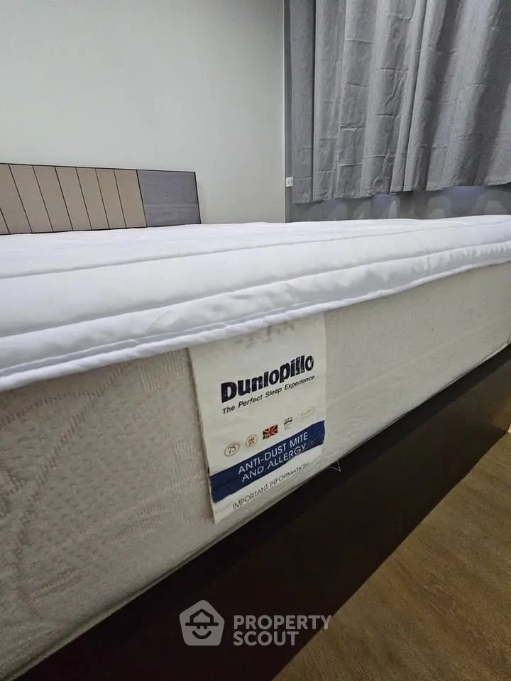 Spacious bedroom with comfortable Dunlopillo mattress and elegant decor, perfect for restful sleep.